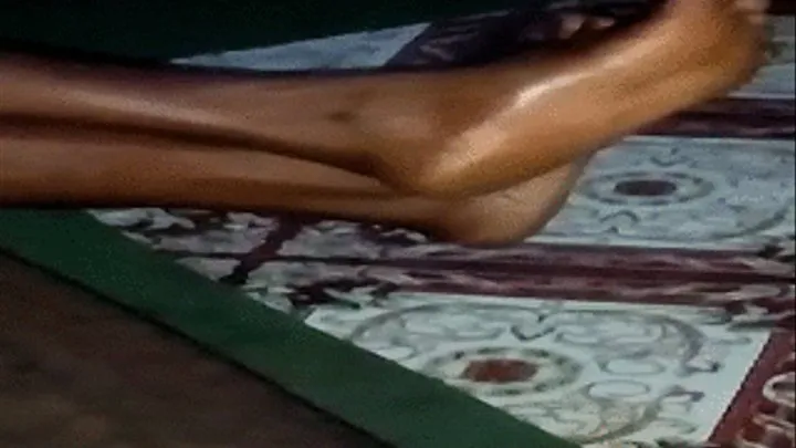 Akweley's Feet Crossed at Ankles From Side Way Angle