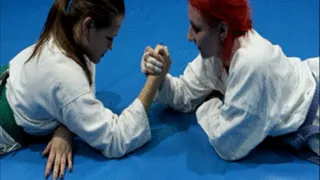 Two girls in white gi armwrestle