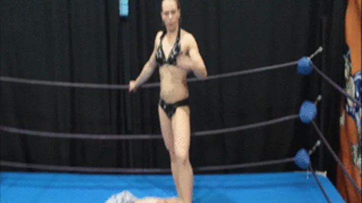 Victory pose with foot on face by female bodybuilder