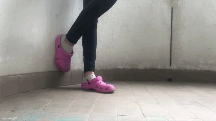 PINK CROCS SHOEPLAY ON A BALCONY