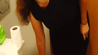 Sexy woman in black dress goes to toilet