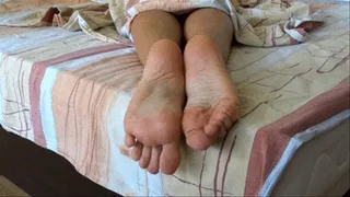 Soles playing on the bed while relaxing - close view feet and toes
