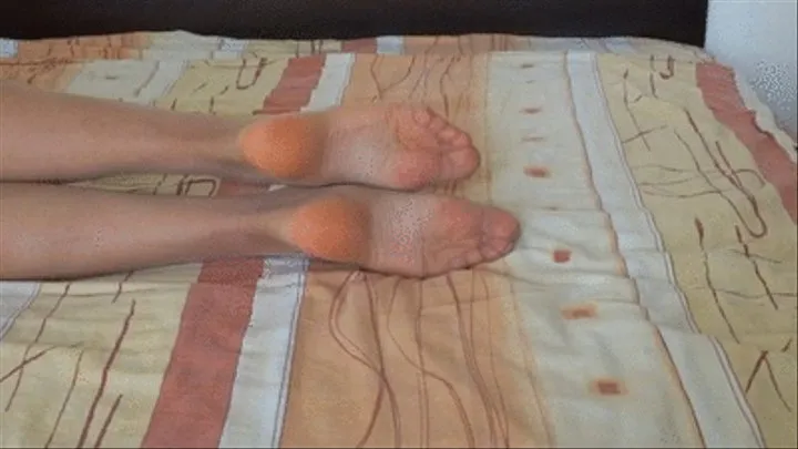 Showing my soles wearing nylon long socks while relaxing on the bed