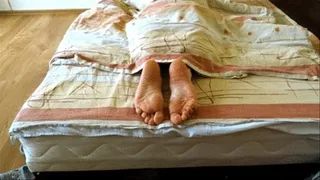 Relaxing barefoot on the bed - soles showing long video