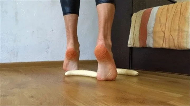 Crushing two bananas into a puree barefoot wearing latex