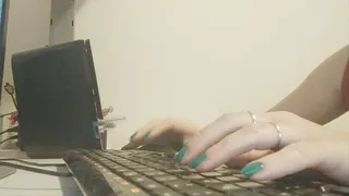 Small hands with green nail polish type on the keyboard quickly