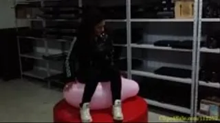Kim Sitting to Pop and Squeezing More Balloons