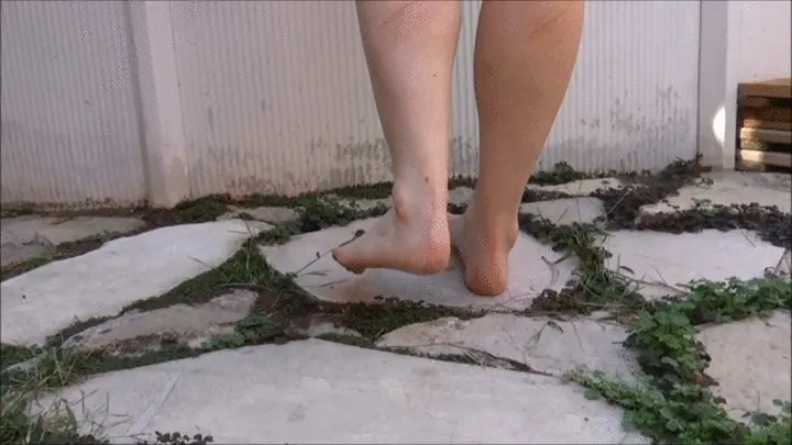 Christine rubs and pull off grass, shows her soles