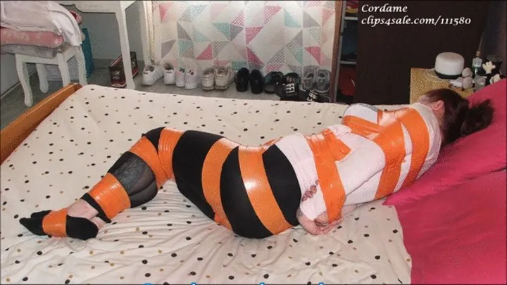 Sandy tied up on bed with orange tape