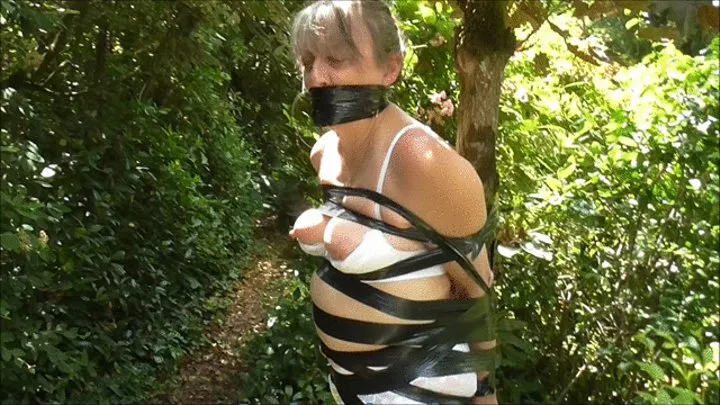 Veronika tied up tight with black tape to a tree