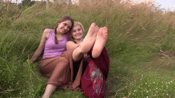 Two amateur girls from street shows their soles on the grass (Part 2)