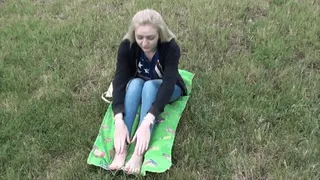Cute blonde shows her big feet on the grass (Part 1)
