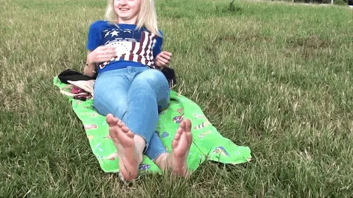 Cute blonde shows her big feet on the grass (Part 4)