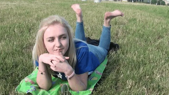 Cute blonde shows her big feet on the grass (Part 5)