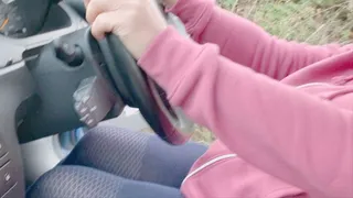 Pumping pedals in a car with bare feet in blue tights