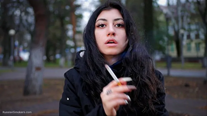 Raven-haired smoker takes a drag on a cigarette of her favorite brand