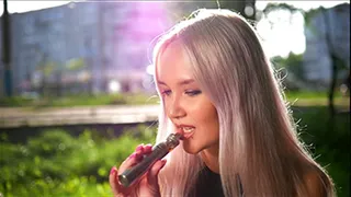 Blonde girl Natalia is vaping on the street