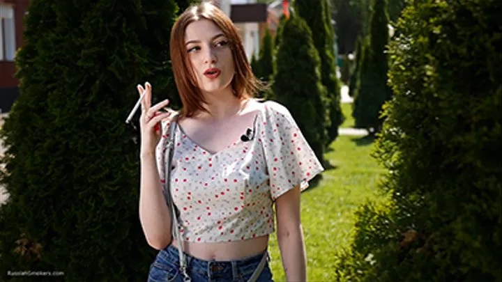 18 y-o Sasha is smoking two white 120mm cigarettes outdoors