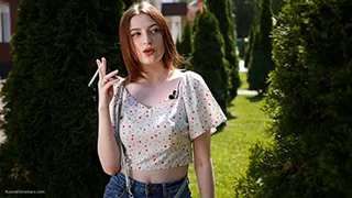 18 y-o Sasha is smoking two white 120mm cigarettes outdoors