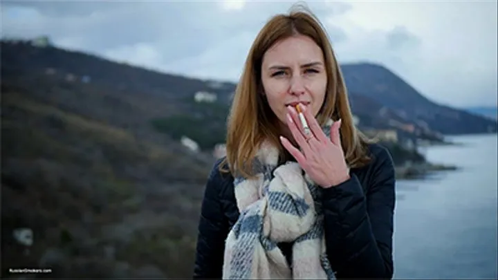 Beautiful lady is smoking two Saratoga cigarettes in a row on a beautiful view