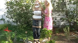 Pretty Party Blonde Serena Sharp Stands Bound to a Post and Cleave Gagged Outdoors - Her Friend Mishel Thinks It's Funny!