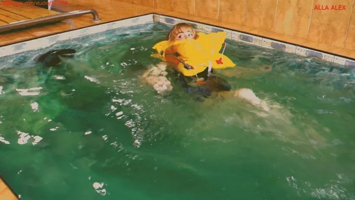 Alla puts on an inflatable life jacket and inflates it automatically and swims in the pool