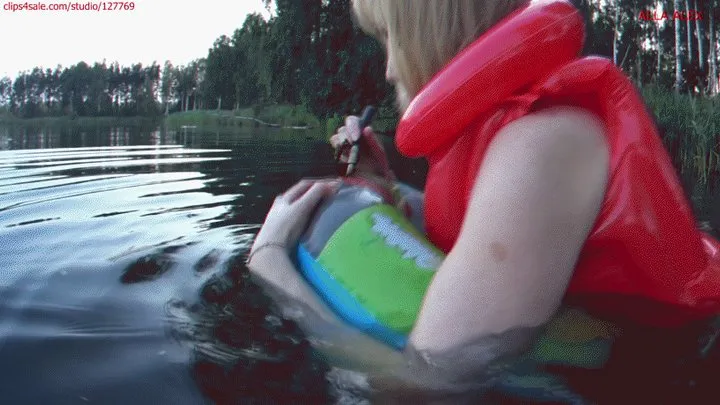 Alla swims on an inflatable ring in the lake and POPs it with a stick and wears a red inflatable vest on her naked body!!!