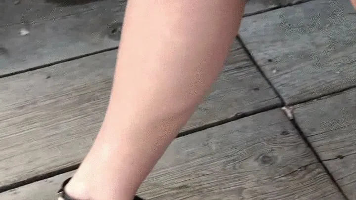 Dasha Kelly is wearing black high heels sandals she walks on a deck with cracks and her heels are thin enough to get stuck