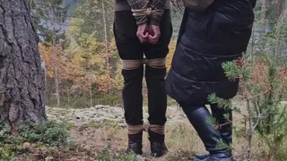 Man in boots hogtied in the woods