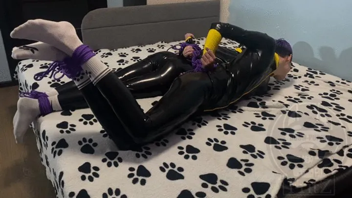 Two bound latex guys play a game of who will fall off the bed first