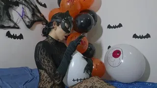 Catwoman on Halloween bursts balloons with her claws