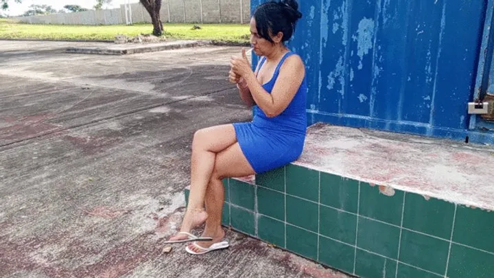 Roxan smoking sitting cross-legged while her flip-flops dangle from her feet (3)