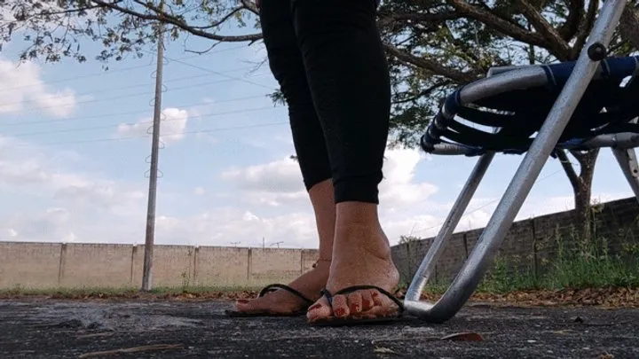 Diosa Angelin with her flip-flops dangling from her feet while cross-legged in the park (1)