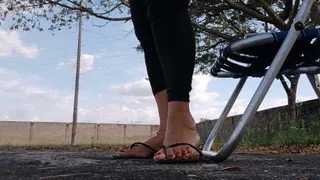 Diosa Angelin with her flip-flops dangling from her feet while cross-legged in the park (1)