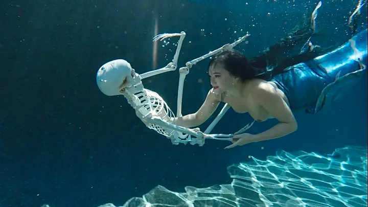 Topless Mermaid Raven Lynette Plays with Skeleton