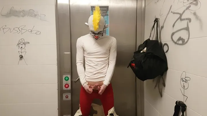 Clown jerking off and putting on condom in public restroom