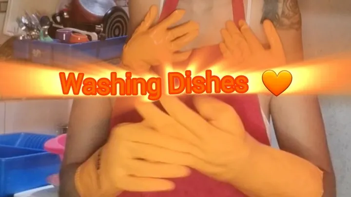 Washing dishes with orange gloves