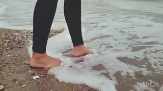 Seule sur le sable, les pieds dans l'eau